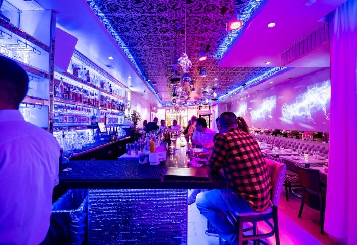Chicago's Kit Kat Lounge & Supper Club: A vibrant gay party venue with a stylish bar, disco balls, and purple lighting. Nightlife destination.