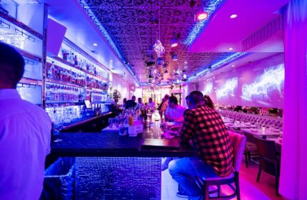 Chicago's Kit Kat Lounge & Supper Club: A vibrant gay party venue with a stylish bar, disco balls, and purple lighting. Nightlife destination.
