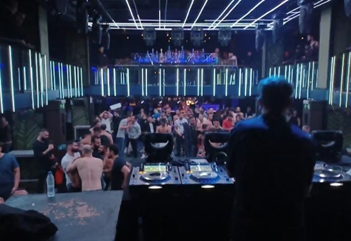 Kluster @ REBEL Gay Club in Madrid: DJ facing a packed dance floor with shirtless men under blue lights. Madrid's gay nightlife scene.