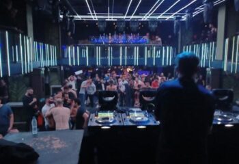 Kluster @ REBEL Gay Club in Madrid: DJ facing a packed dance floor with shirtless men under blue lights. Madrid's gay nightlife scene.