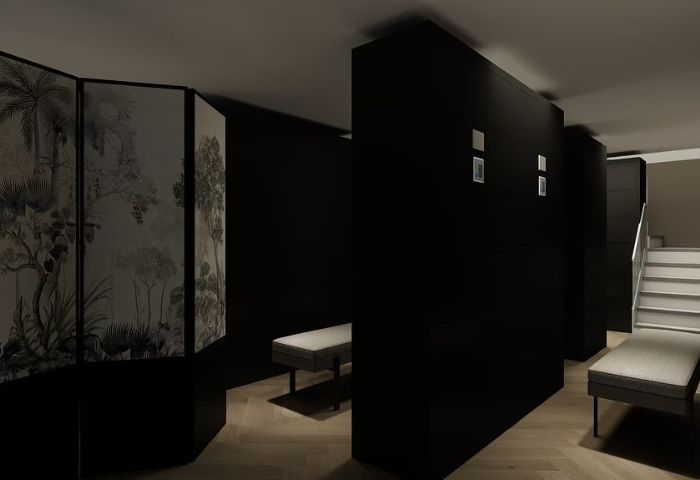 Interior of Kuma Club Las Vegas, a gay bathhouse. Dark walls, benches, and a decorative screen create a modern, intimate space.