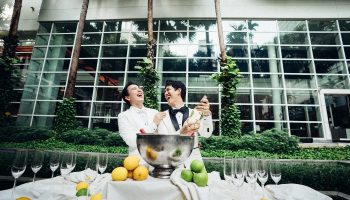 Bangkok King Power Pullman LGBTQ wedding. Two grooms open champagne, celebrating their gay wedding in Bangkok, Thailand.