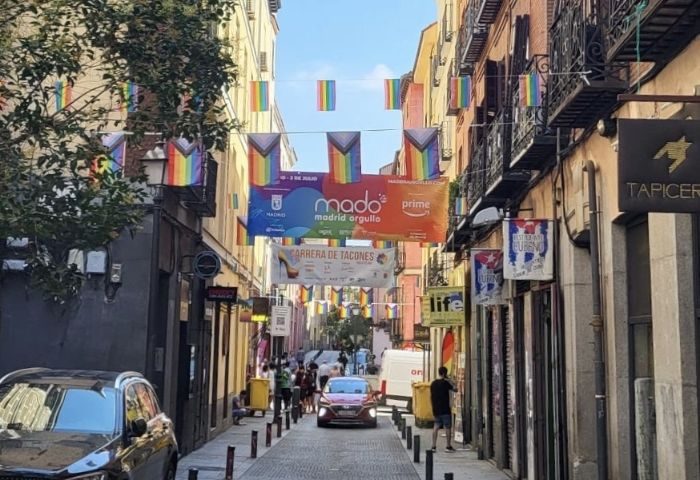 Gay bar in Madrid street view. Rainbow flags and MADO banners decorate the street for Madrid Pride, a popular gay travel destination.