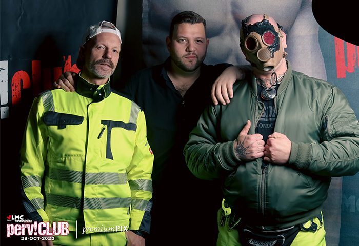 LMC Vienna HARD ON: Three men at a gay event. One in hi-vis, one in a gas mask, promoting gay travel advice. LMC-Vienna.jpg