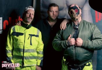 LMC Vienna HARD ON: Three men at a gay event. One in hi-vis, one in a gas mask, promoting gay travel advice. LMC-Vienna.jpg