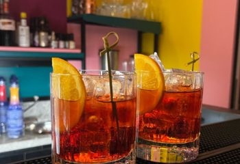 Milan's LOLA bar: Two Negroni cocktails with orange slices and ice. Gay travel advice for the best Milan bars and nightlife spots.