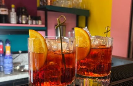Milan's LOLA bar: Two Negroni cocktails with orange slices and ice. Gay travel advice for the best Milan bars and nightlife spots.