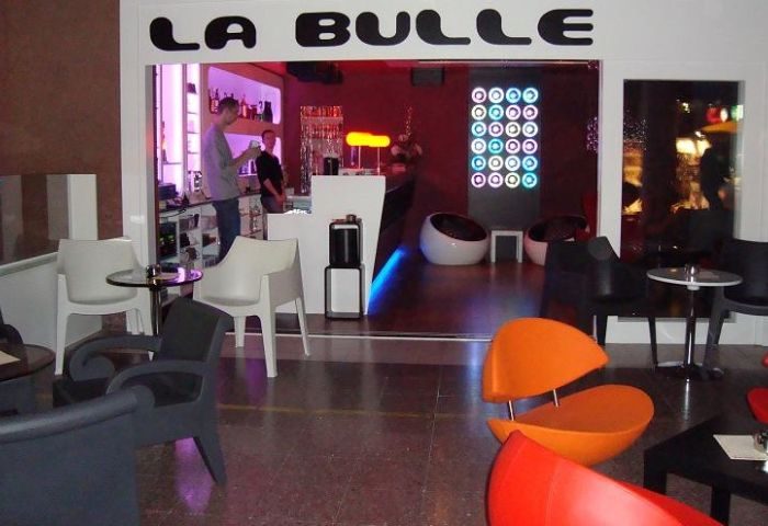 La Bulle Gay Bar in Gran Canaria, Spain. Interior view with colorful chairs, bar area, and modern design. Gay travel destination.