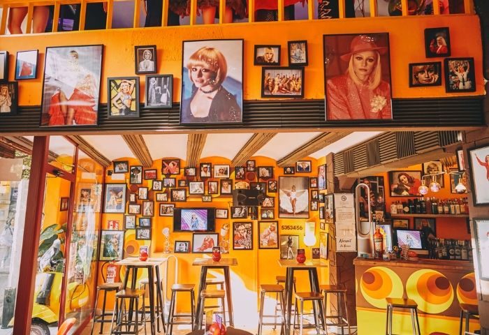 Interior of La Carra Gay Bar in Barcelona. Walls are adorned with La Carra photos. A vibrant, welcoming space for gay travelers.