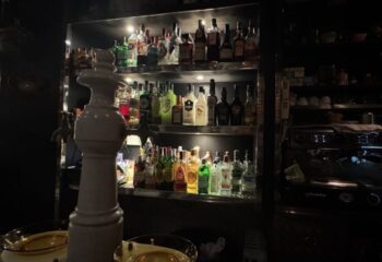 La Chapelle Gay Bar in Barcelona: Shelves stocked with liquor bottles. A stylish gay bar, part of Barcelona's LGBTQ+ scene.