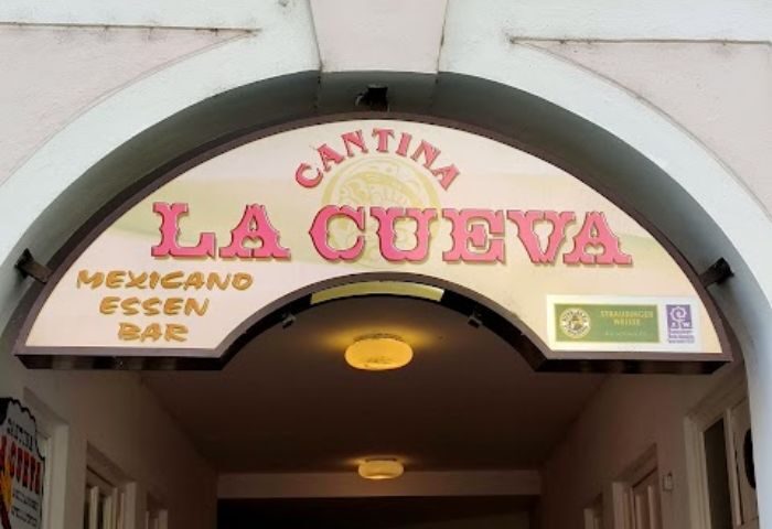 La Cueva Cantina sign in Puerto Vallarta. Gay bar entrance with 'Cantina La Cueva' in pink letters. Mexicano Essen Bar.