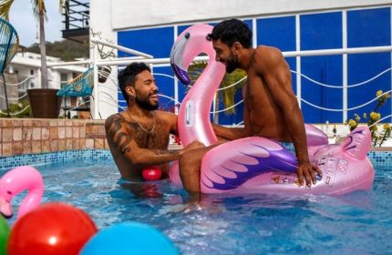 La Iguana Vallarta LGBT adults only. Two men in a pool with a flamingo floatie in Romantic Zone. Party Clubbing Street scene.