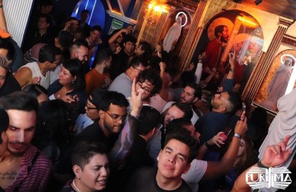 La Purisima Gay Bar in Mexico: A lively, crowded scene inside the popular gay bar. People are dancing and socializing under religious-themed decor.
