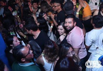 Crowded La Purisima gay bar in Mexico. Diverse group of people dancing, drinking, and enjoying the vibrant atmosphere. Gay travel nightlife.