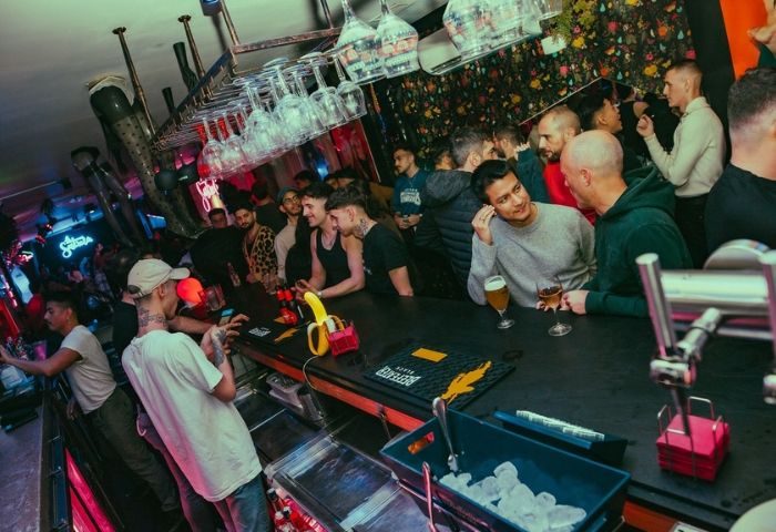 Inside La Sastreria gay bar in Barcelona, Spain. Men at the bar, drinking, socializing. Popular gay travel destination. Nightlife.