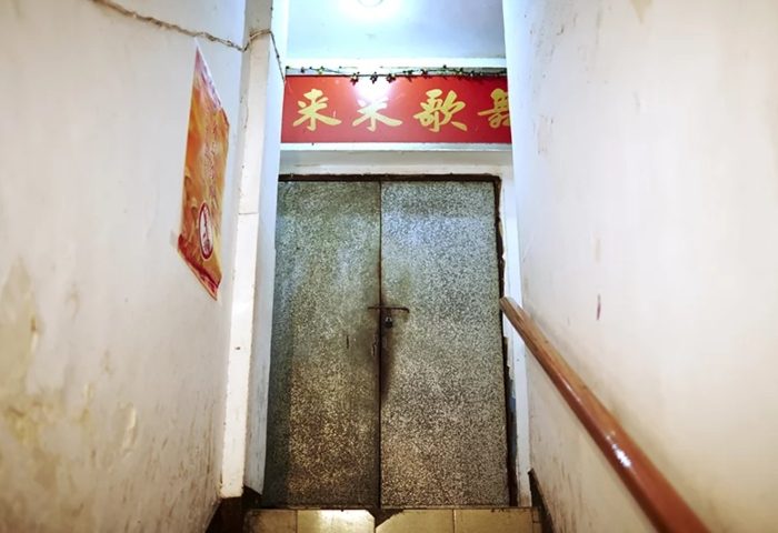 Stairs leading to Lai Lai Dance Hall, a gay nightlife spot. A red sign with Chinese characters above a metal door. Gay travel destination.