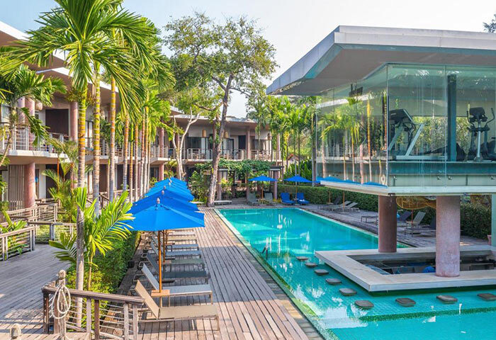 Sai Kaew Beach Resort pool view. Laid-back luxury vibe at this Koh Samet gay hotel. Super cheap, palm trees, blue umbrellas, gym.