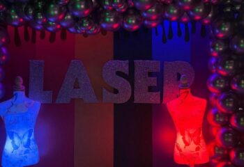 Laser Hot Bar for queers in Cancun: Entrance with mannequins, balloons, and colorful lighting. Gay travel advice for Cancun nightlife.