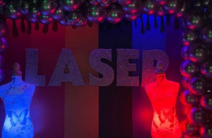 Laser Hot Bar for queers in Cancun: Entrance with mannequins, balloons, and colorful lighting. Gay travel advice for Cancun nightlife.