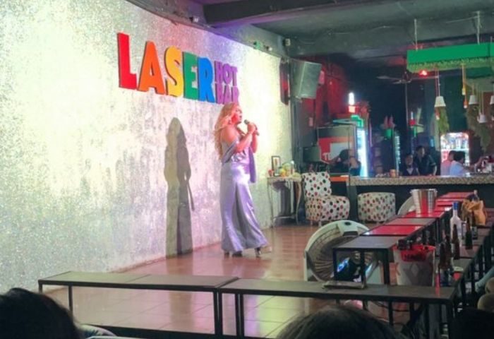 Drag queen performing at Laser Hot Bar, a popular gay bar in Cancun. Nightlife scene with stage, bar, and audience.