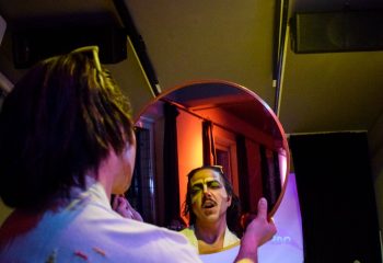 A gay man in Rome applies makeup, reflected in a mirror. Latte Fresco event. Rome travel, gay travel advice, queer nightlife.