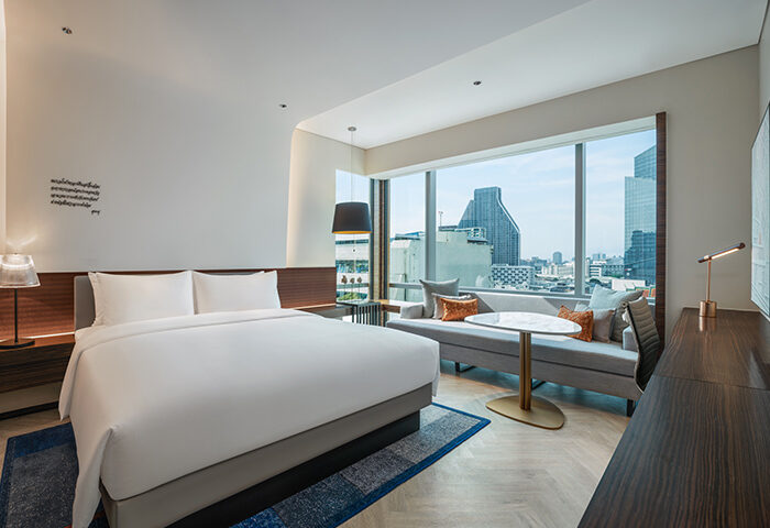 Le Méridien Bangkok hotel room featuring a king-size bed, a city view, and modern decor. Top gay hotel on Silom gayborhood for gay travelers.