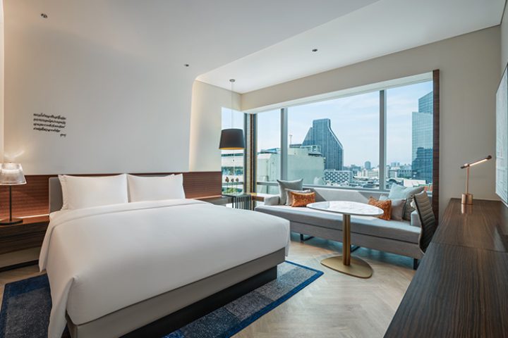 Le Méridien Bangkok hotel room featuring a king-size bed, a city view, and modern decor. Top gay hotel on Silom gayborhood for gay travelers.