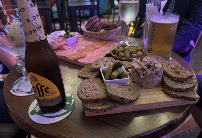Le Mixx Gay Bar in Gran Canaria: Drinks and tapas selection, featuring beer, wine, bread, olives, and cured meats. Gay travel.