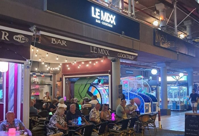 Le Mixx Gay Bar in Gran Canaria. Outdoor seating area with patrons. Nightlife scene at a popular gay bar. Bar and cocktails.