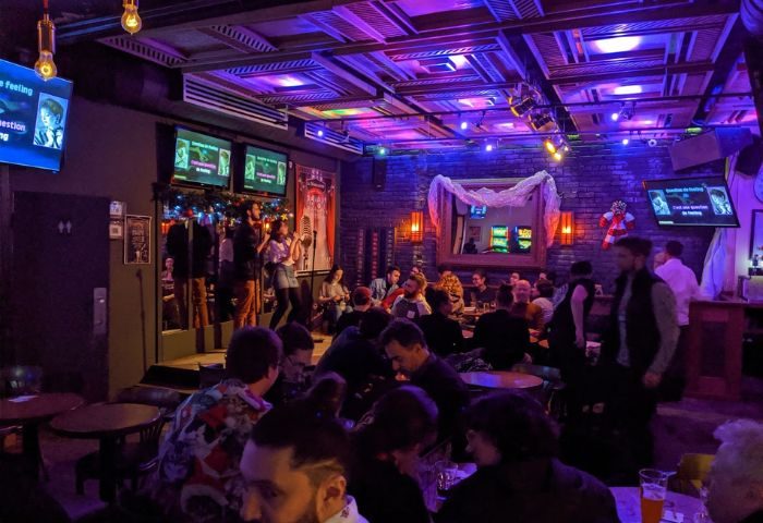 Inside Le Taverne Normandie, a gay bar in Montreal, with karaoke, drinks, and a lively crowd. A popular spot for gay men's travel.