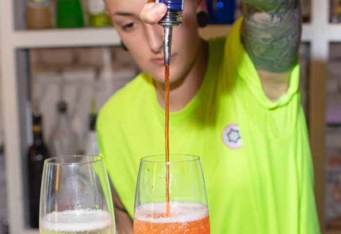 Lecco Milan: Bartender pours Aperol into sparkling wine for a cocktail. Gay travel advice for nightlife in Milan, Italy.