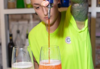 Lecco Milan: Bartender pours Aperol into sparkling wine for a cocktail. Gay travel advice for nightlife in Milan, Italy.