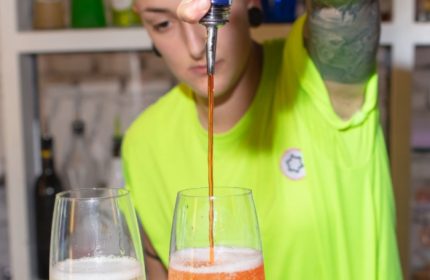 Lecco Milan: Bartender pours Aperol into sparkling wine for a cocktail. Gay travel advice for nightlife in Milan, Italy.