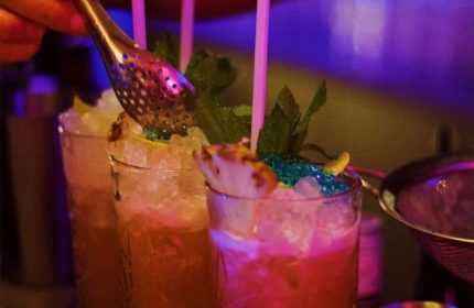 Cocktails at a gay bar in New York. Refreshing drinks with ice, mint, and fruit garnishes. Part of the gay cruise and bar scene.