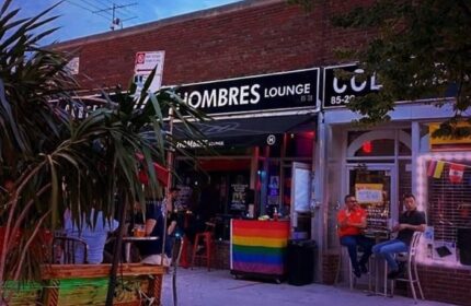 Les Hommes gay bar in New York. Outdoor seating at gay bar with rainbow flag. Gay travel advice for New York City gay scene.