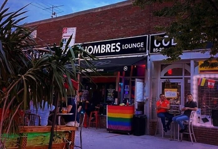 Les Hommes gay bar in New York. Outdoor seating at gay bar with rainbow flag. Gay travel advice for New York City gay scene.