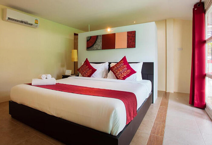 Lima Coco Resort room. Cheap beachfront gay hotel with pool. King bed with red accents. Modern, clean design. Perfect for gay travel.