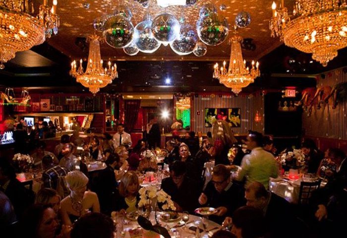 Lips Drag Queen Show Palace in New York. Interior view of the restaurant, chandeliers and disco balls hanging from the ceiling, people dining.