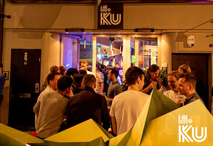 Little KU, London's coolest gay bar in Soho. Men gather outside Little KU, a popular gay bar, enjoying drinks and socializing.