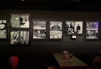 Lo de Carmen Gay Bar, Barcelona. Wall art, skull decor, and drinks on a table. Gay travel advice, nightlife scene.
