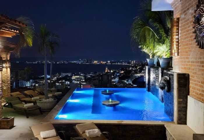 Night view of The Lookout gay bar in Puerto Vallarta. Infinity pool overlooking the city skyline. Gay travel destination.