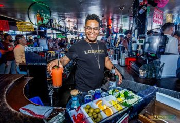 Bartender at Lookout, a gay bar in San Francisco, prepares a cocktail. Nightlife scene with a diverse crowd. Gay travel destination.