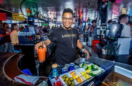 Bartender at Lookout, a gay bar in San Francisco, prepares a cocktail. Nightlife scene with a diverse crowd. Gay travel destination.