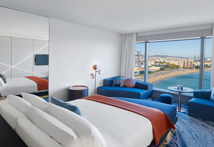 W Barcelona luxury hotel room with beach view. Gay-friendly travel lodging with modern design and city skyline.