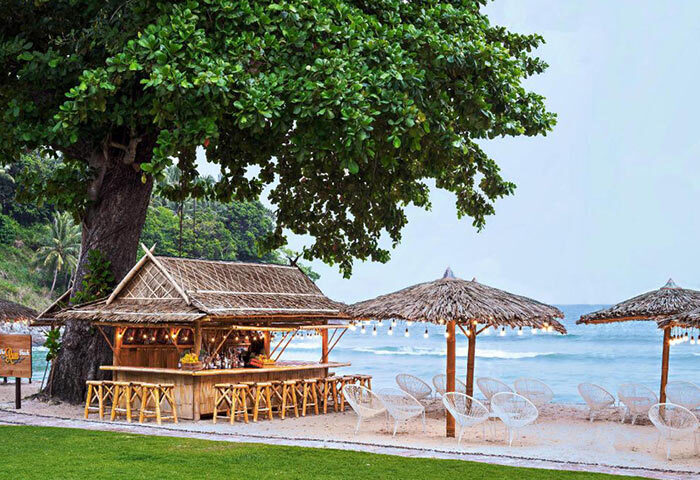 Beachfront bar at Phuket Marriott Resort & Spa, Merlin Beach. Luxury gay-friendly hotel in Phuket. Tropical beach bar with chairs and umbrellas.