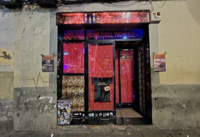 Madame Jasmine Gay Bar in Barcelona. Exterior view of the bar, with neon signs and red curtains, a popular gay travel destination.