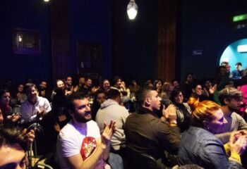 Audience applauding at Malo Glitter Bar in Rome. Gay men travel advice: a vibrant, inclusive space for entertainment and community.