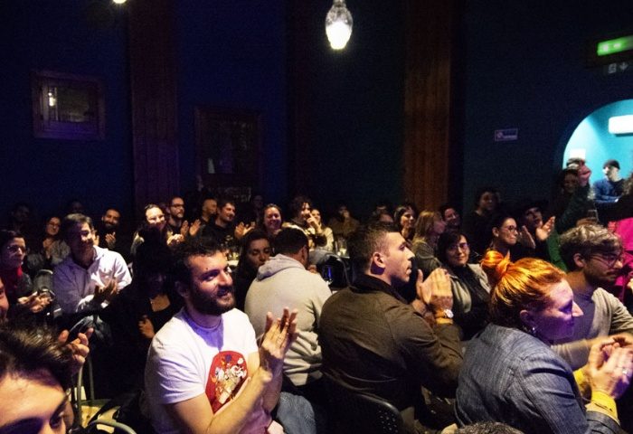 Audience applauding at Malo Glitter Bar in Rome. Gay men travel advice: a vibrant, inclusive space for entertainment and community.