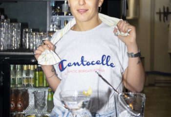 Malo Glitter Bar Rome: Bartender with Centocelle shirt, serving drinks. Gay travel advice for Rome's nightlife, bars, and gay-friendly spots.