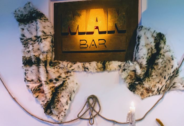 Man Bar sign in Sitges, a gay bar destination. The sign is decorated with faux fur and rope, creating a unique, rustic aesthetic.